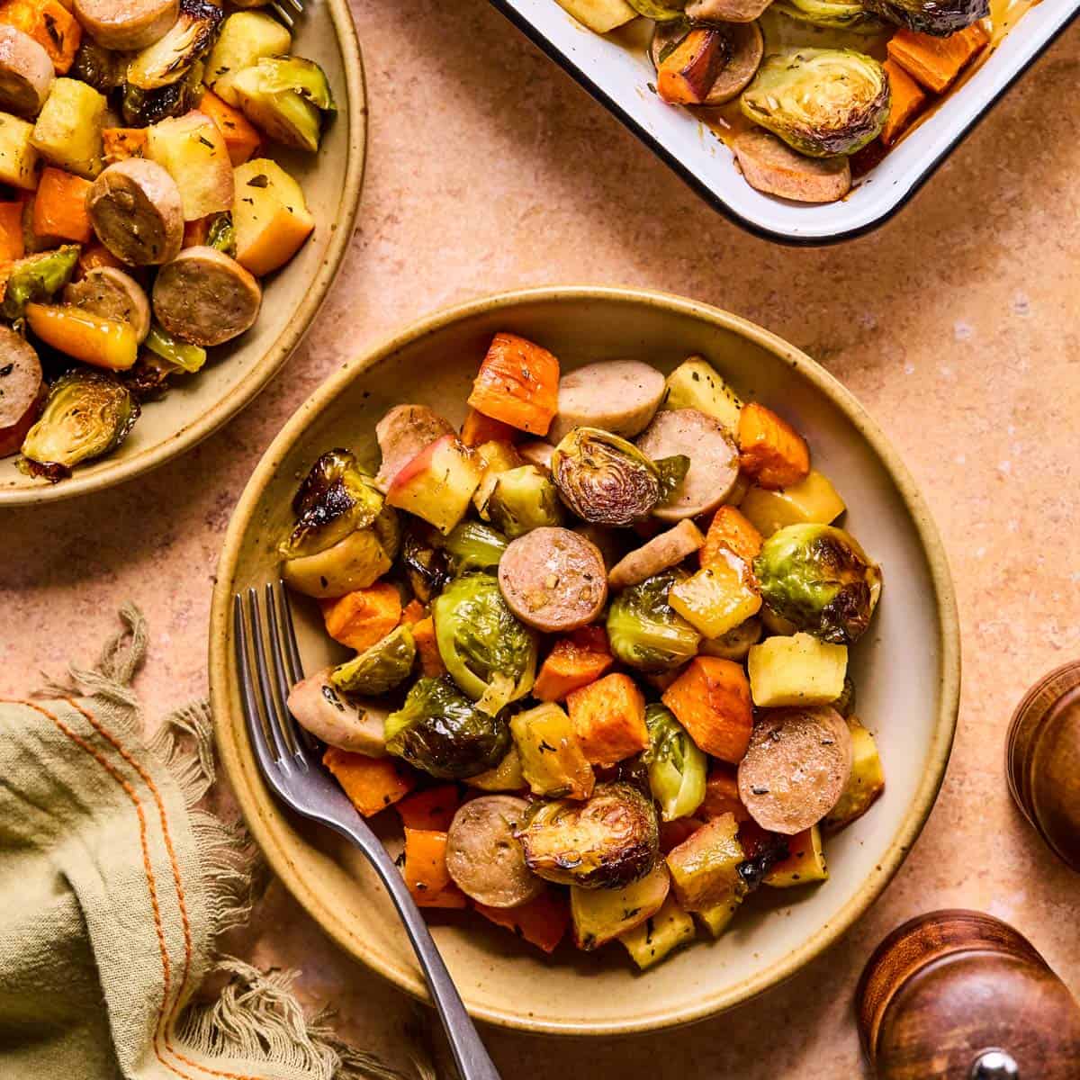 fork resting on a plate of maple dijon sausage and veggies.