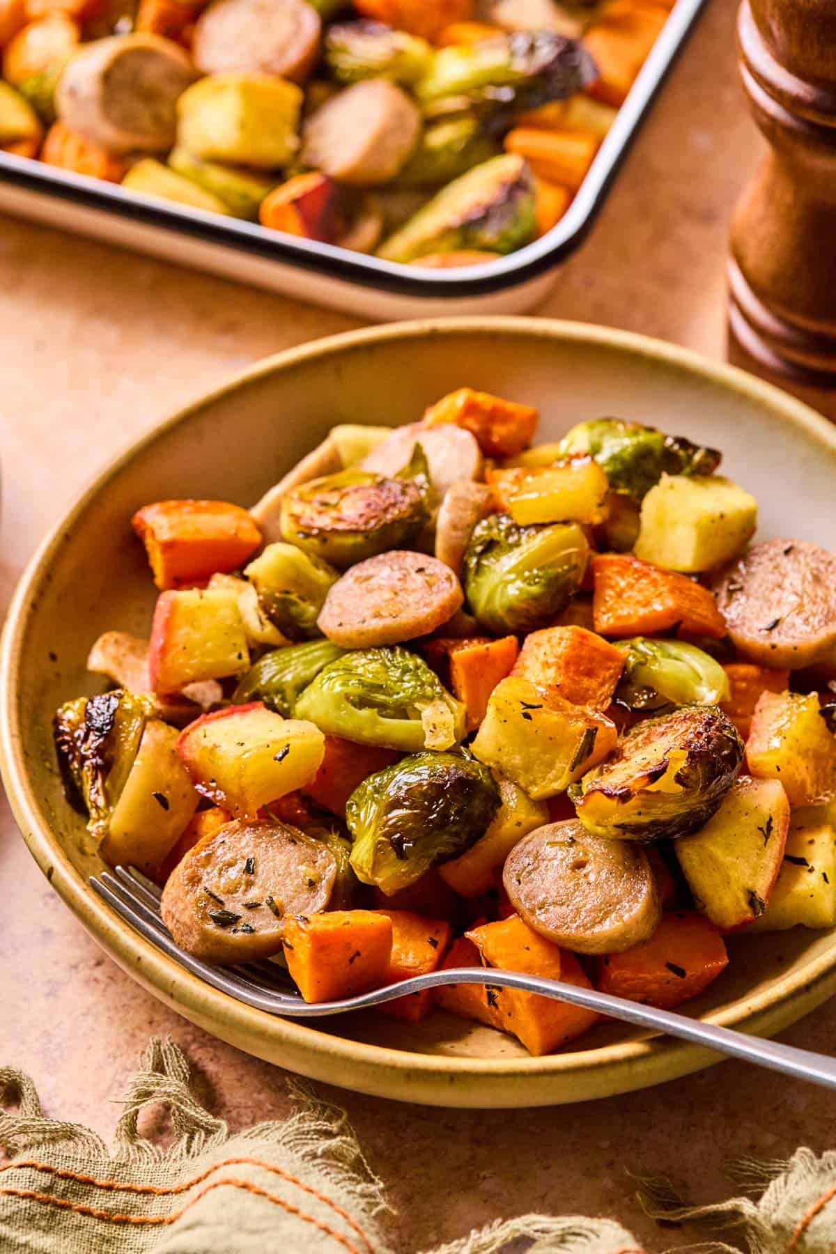 plate of maple dijon sausage and veggies with a fork scooped into the food.