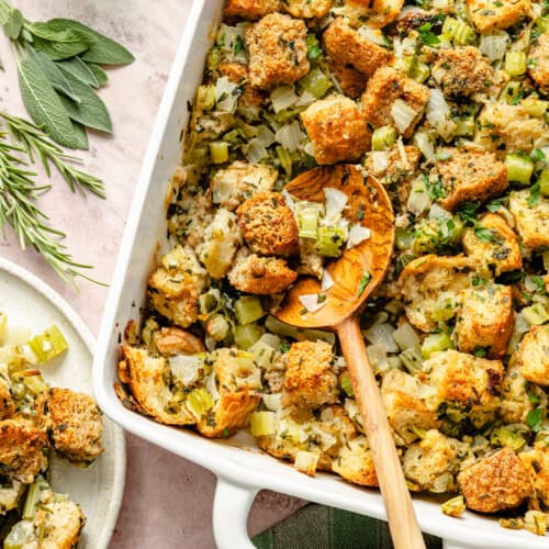 homemade stuffing recipe in a casserole dish with a serving spoon.