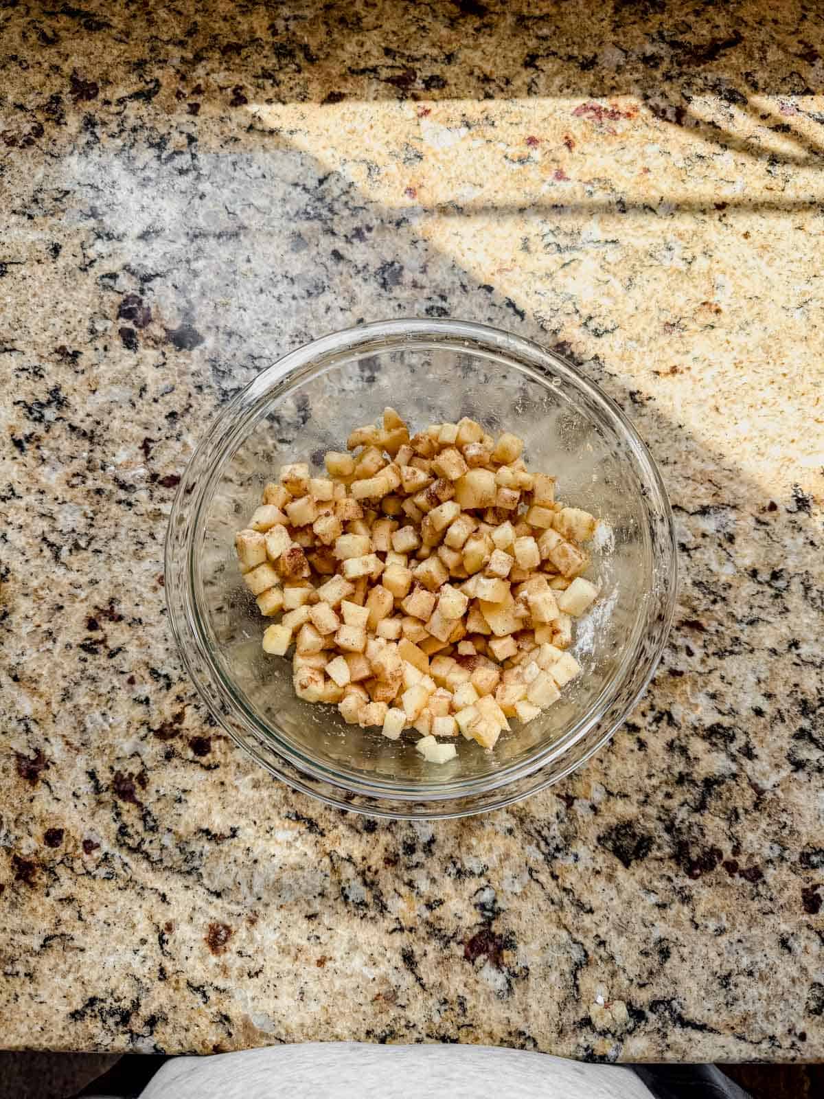 apple pie filling with small diced apples mixed in a glass bowl.
