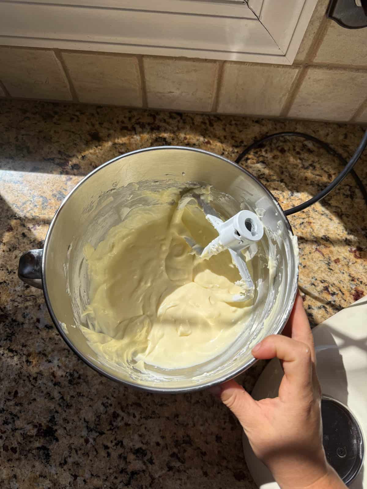 homemade cheesecake batter in the bowl of a stand mixer.
