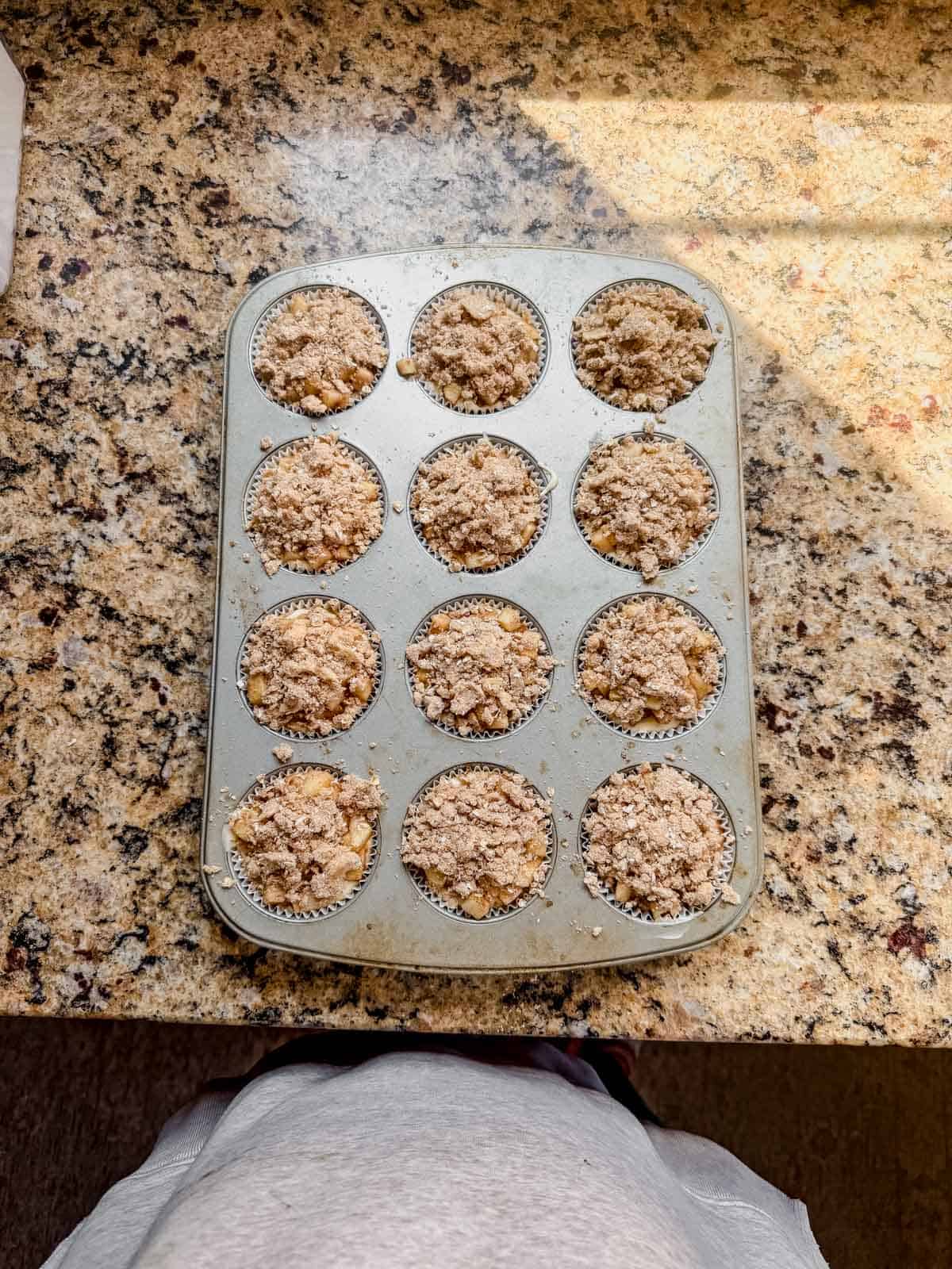 apple crisp mini cheesecakes cooling on a counter top.