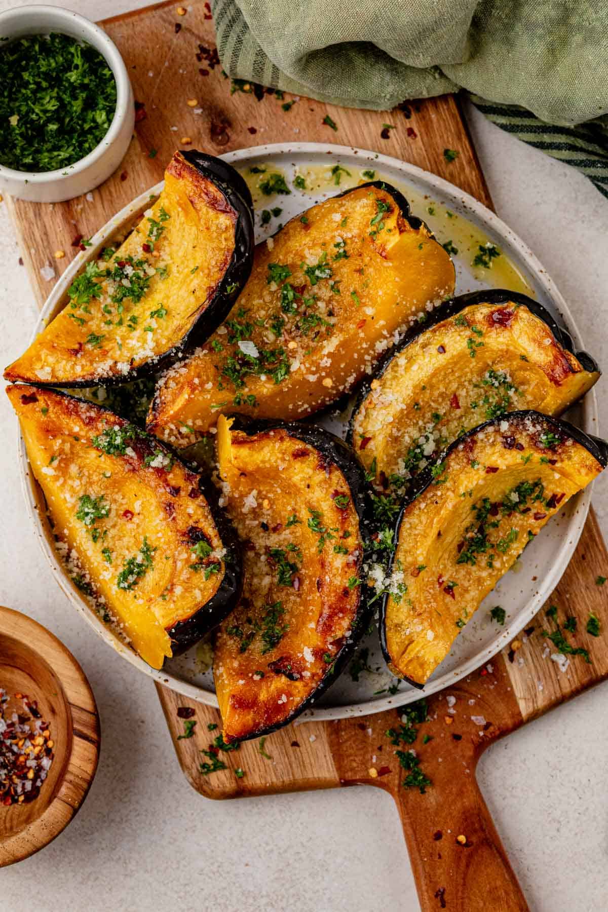 roasted acorn squash wedges on a serving plate.