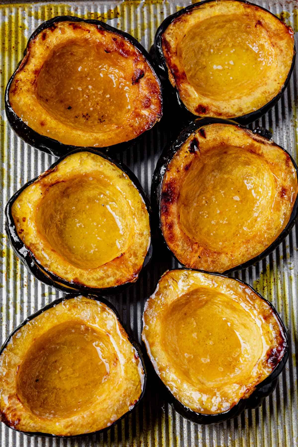 roasted acorn squash cooling on a baking sheet.