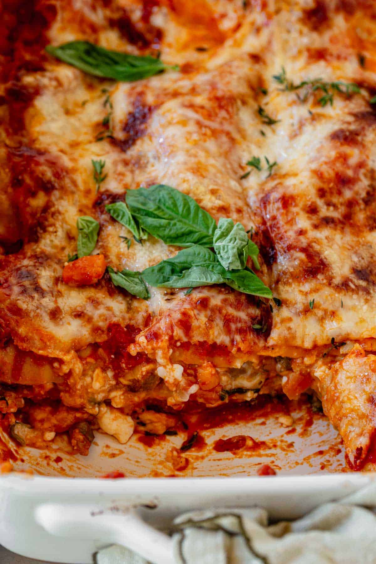 cottage cheese vegetable lasagna in a casserole dish with a slice missing, showing the layers.
