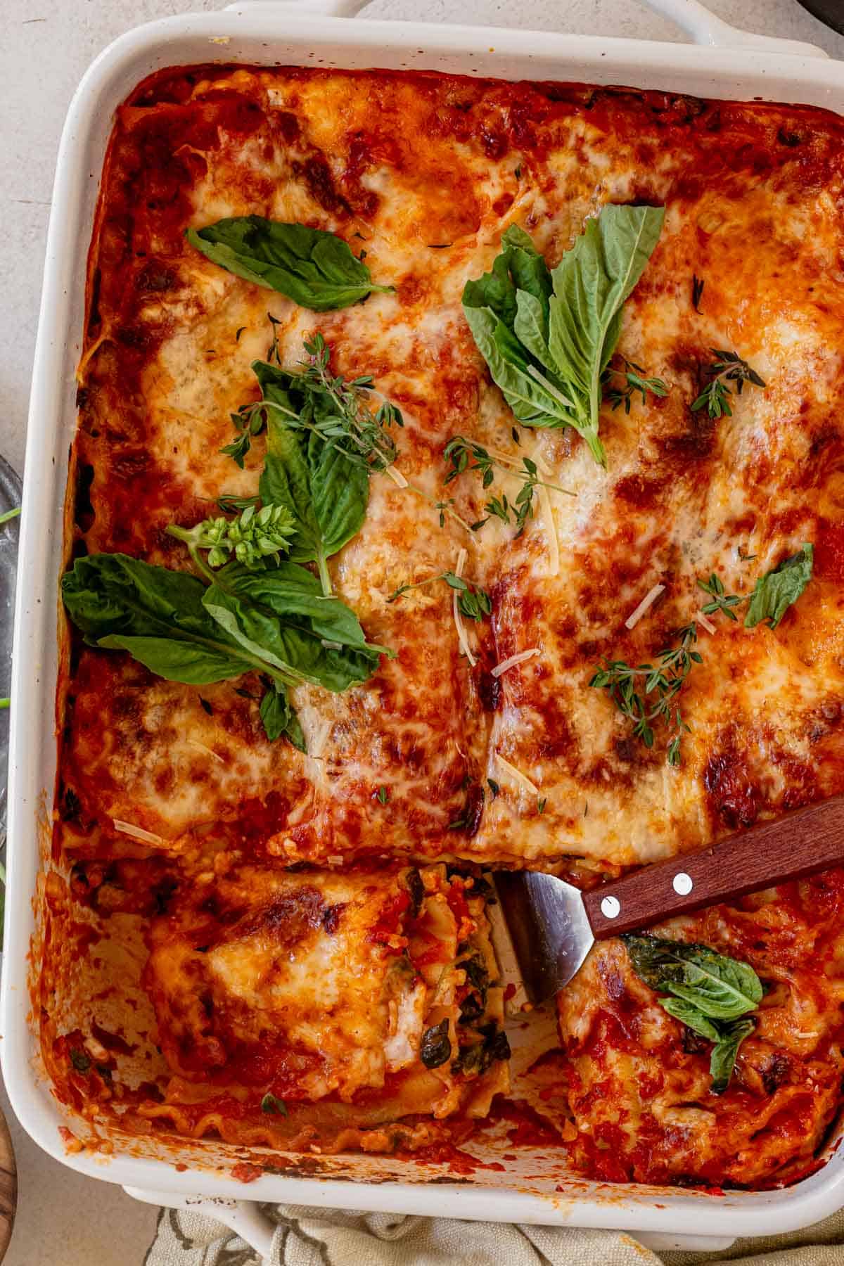 a pan of cottage cheese vegetable lasagna topped with fresh basil.