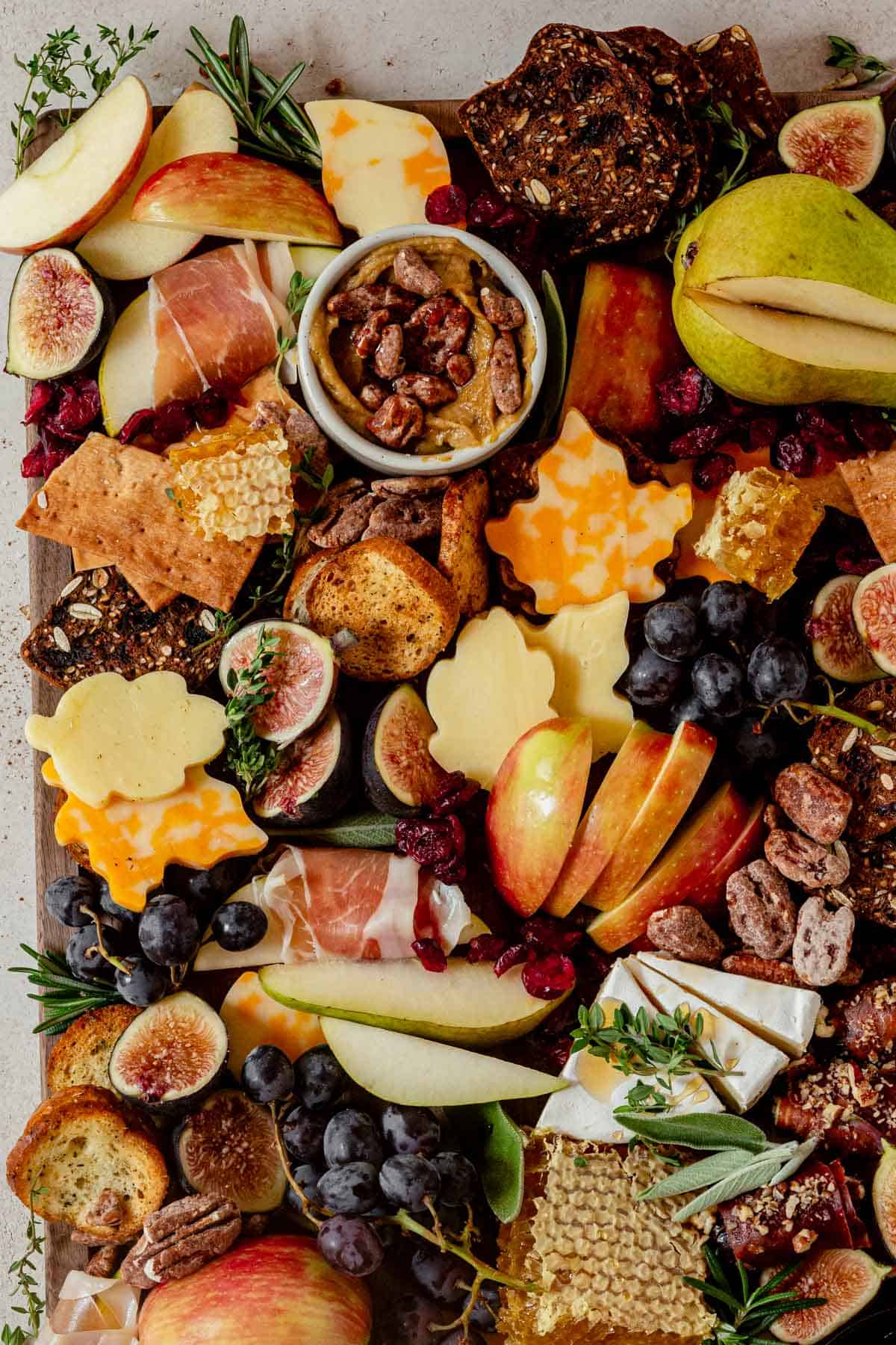 pumpkin butter, pears, black grapes, and cheese on a fall cheese board.