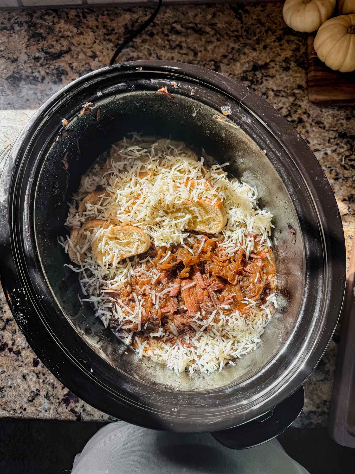 french onion pot roast topped with crusty bread slices and shredded cheese.