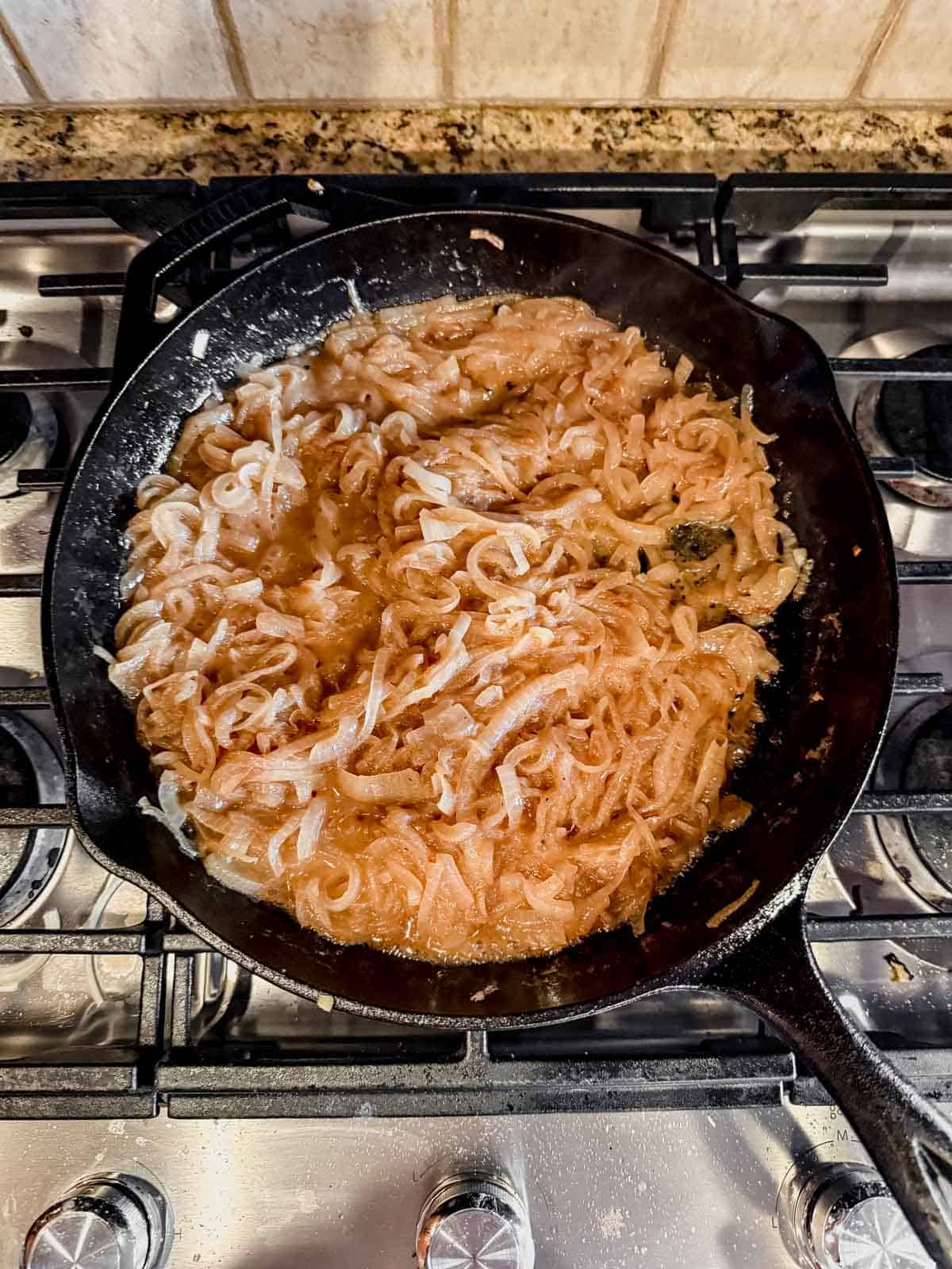 caramelizing onions on the stove in a cast iron skillet.
