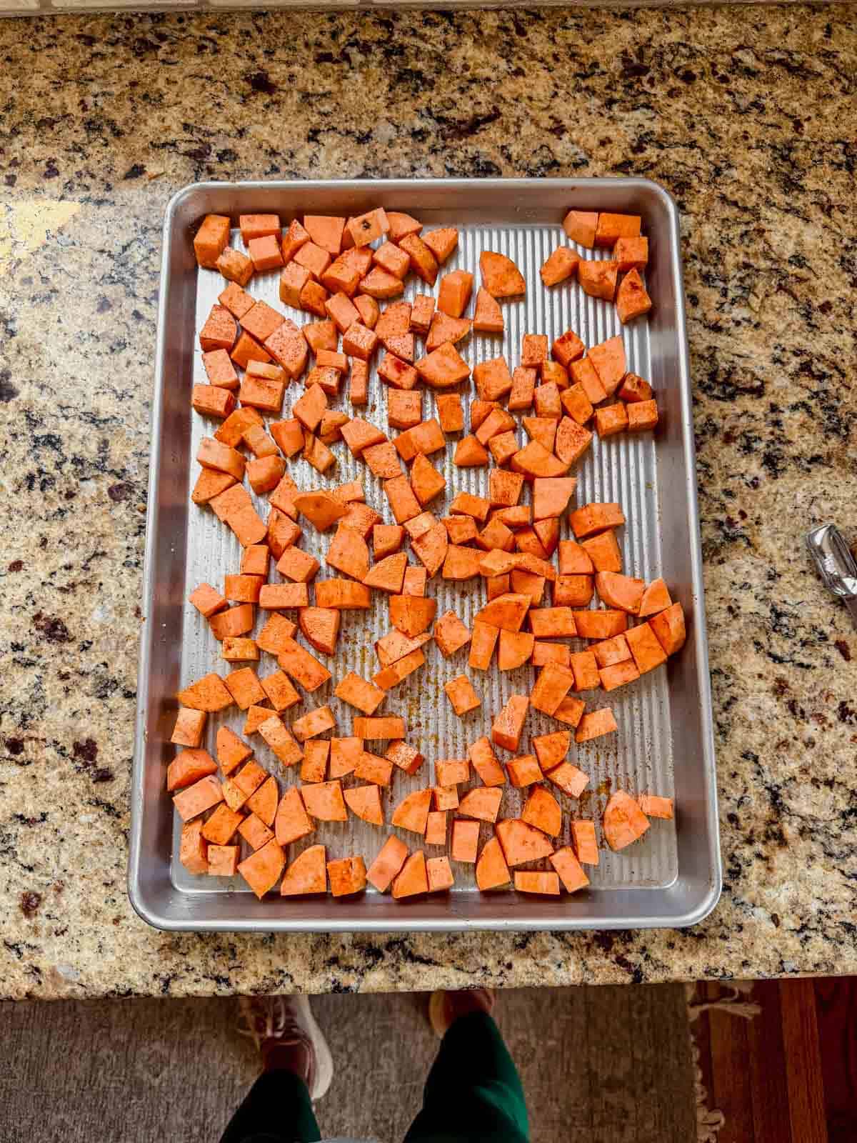 peeled and cubed sweet potatoes on a baking sheet.