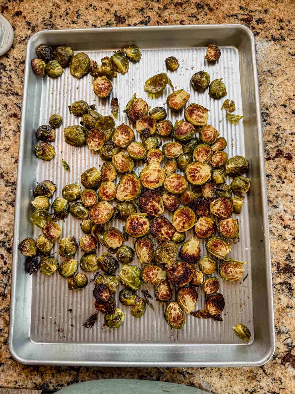 crispy and slightly charred brussel sprouts on a sheet pan.