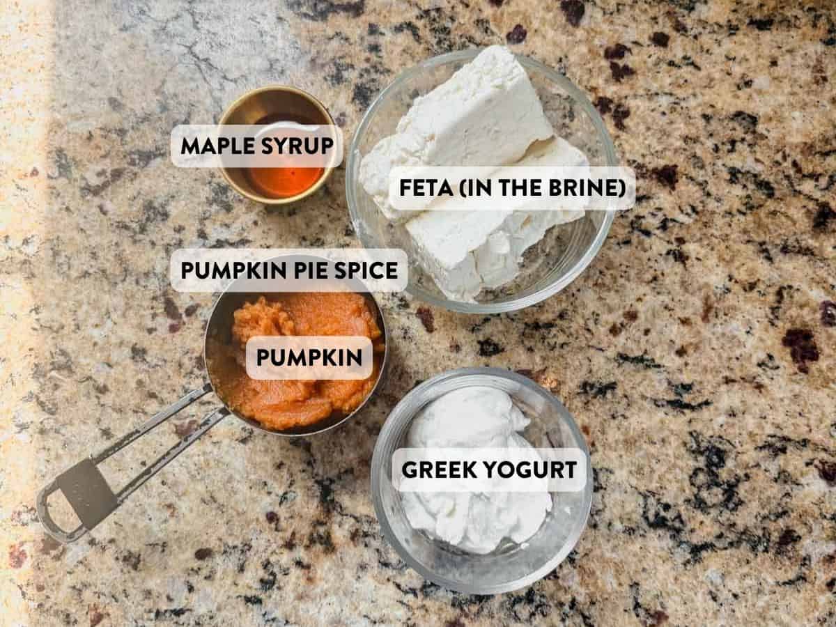feta, greek yogurt, pumpkin puree, maple syrup, and pumpkin pie spice on a counter.
