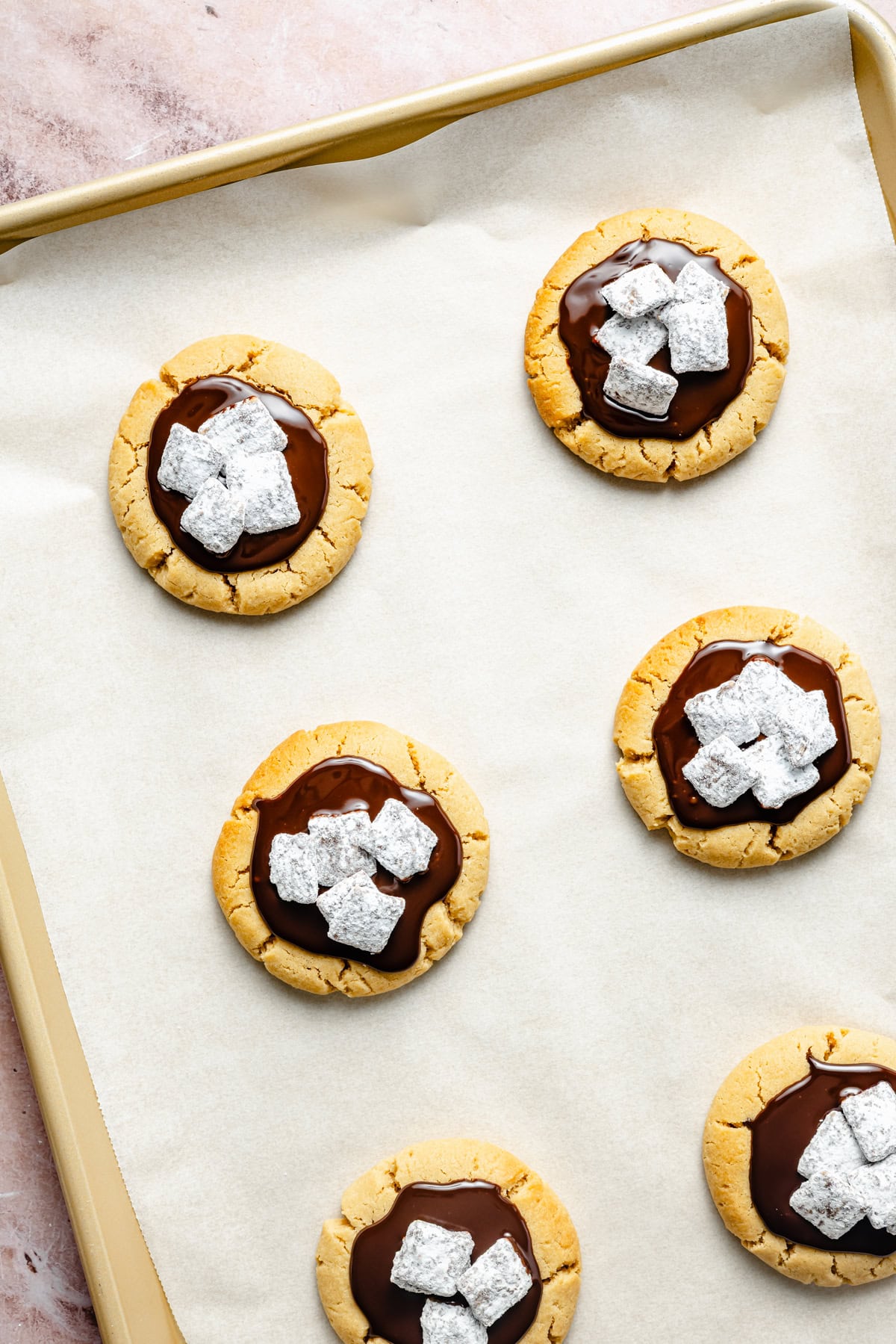 muddy buddy cookies topped with homemade puppy chow on a baking sheet.