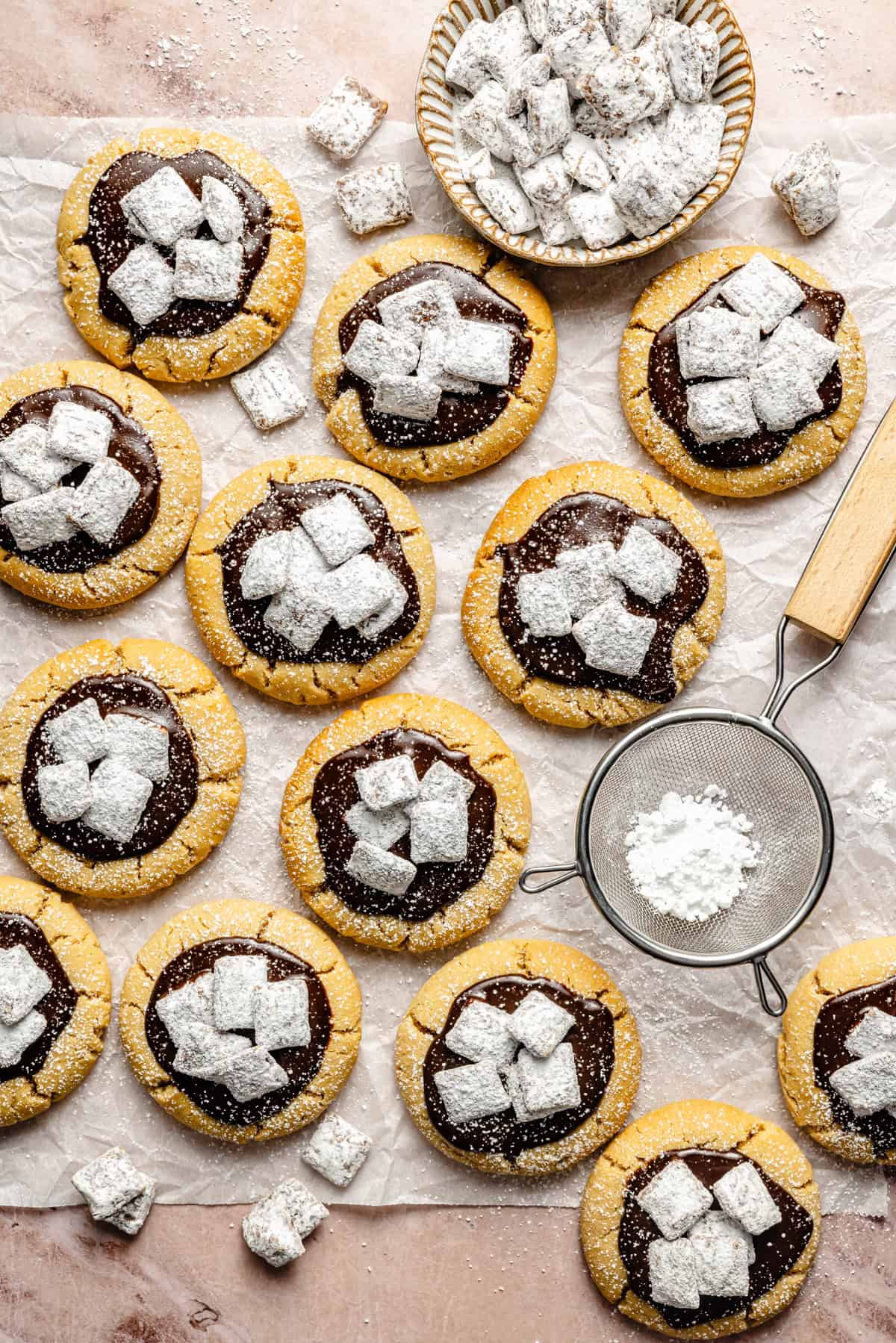 a batch of muddy buddy cookies on a piece of parchment paper.