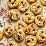 a batch of peppermint chocolate chip cookies cooling on a wire rack.