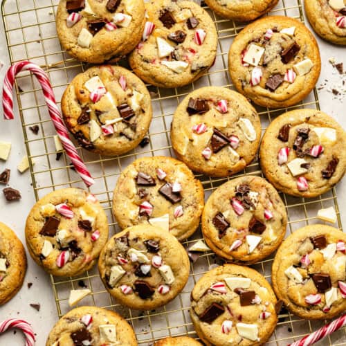a batch of peppermint chocolate chip cookies cooling on a wire rack.