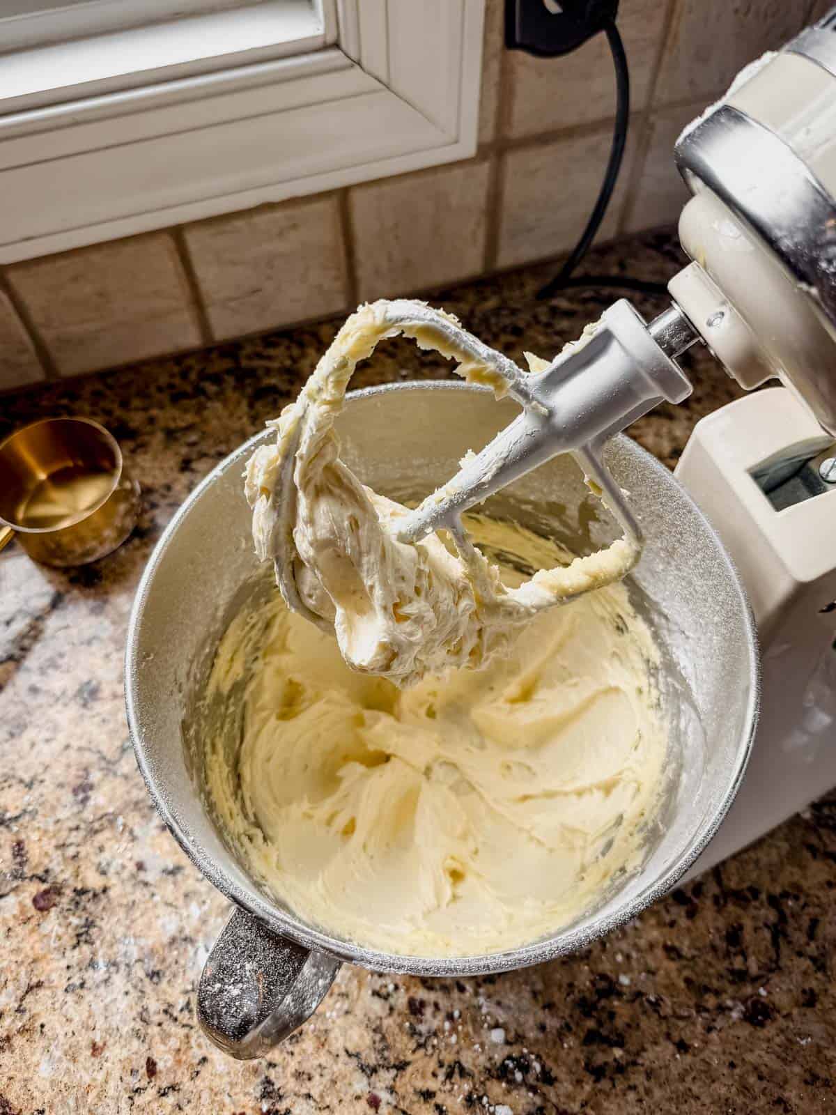 beating eggnog frosting in a stand mixer.