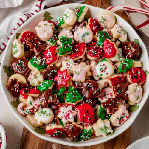 a bowl of decorated mini christmas cookies.