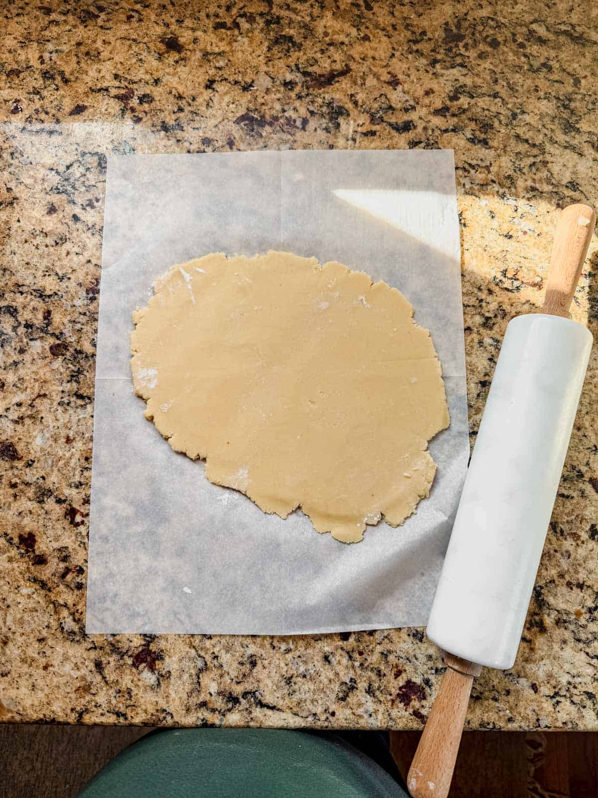christmas sugar cookie dough rolled out on parchment paper.