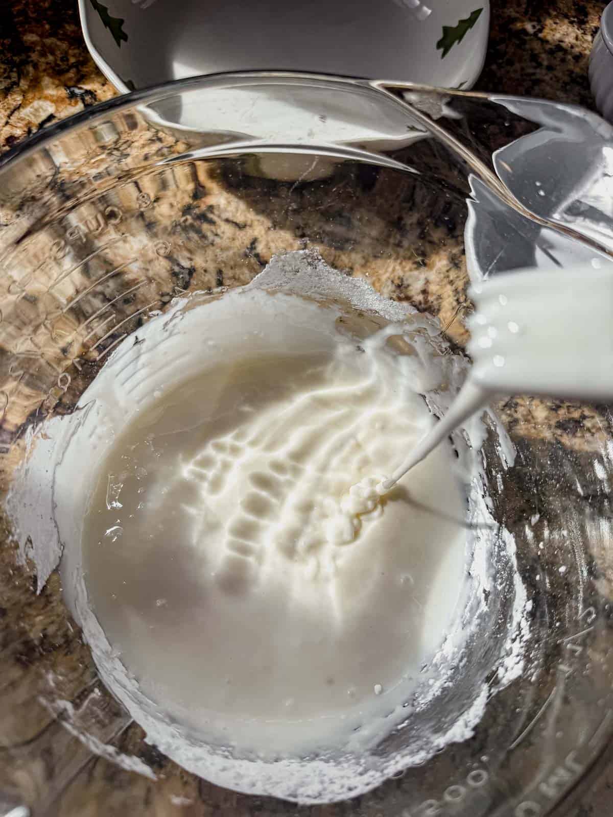 whisking cookie icing in a bowl for decorating.