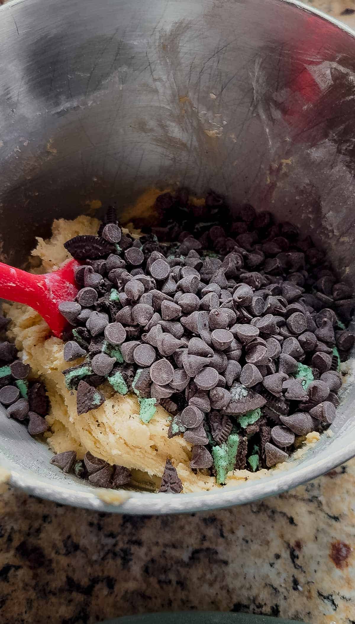 stirring chocolate chips and crushed mint oreos into cookie dough.