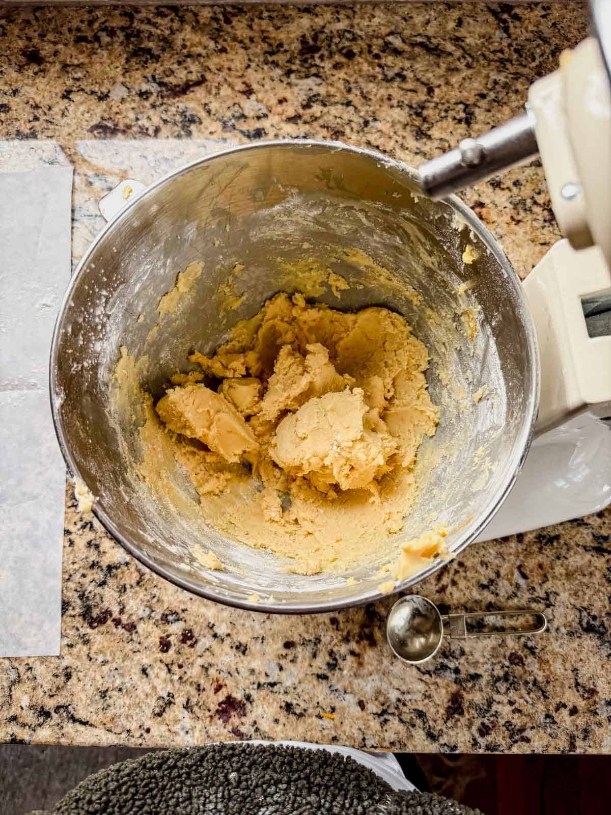 orange shortbread cookie dough in a stand mixer bowl.