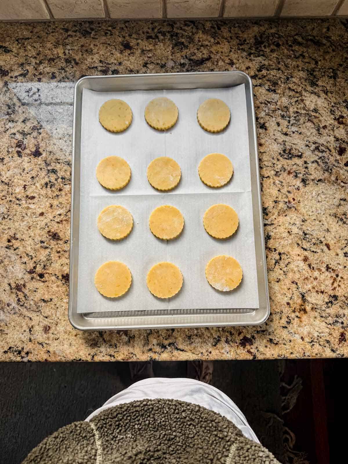 orange shortbread cookies on a parchment lined baking sheet.