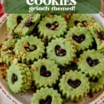 green pistachio linzer cookies with hearts cut out stacked on a christmas plate