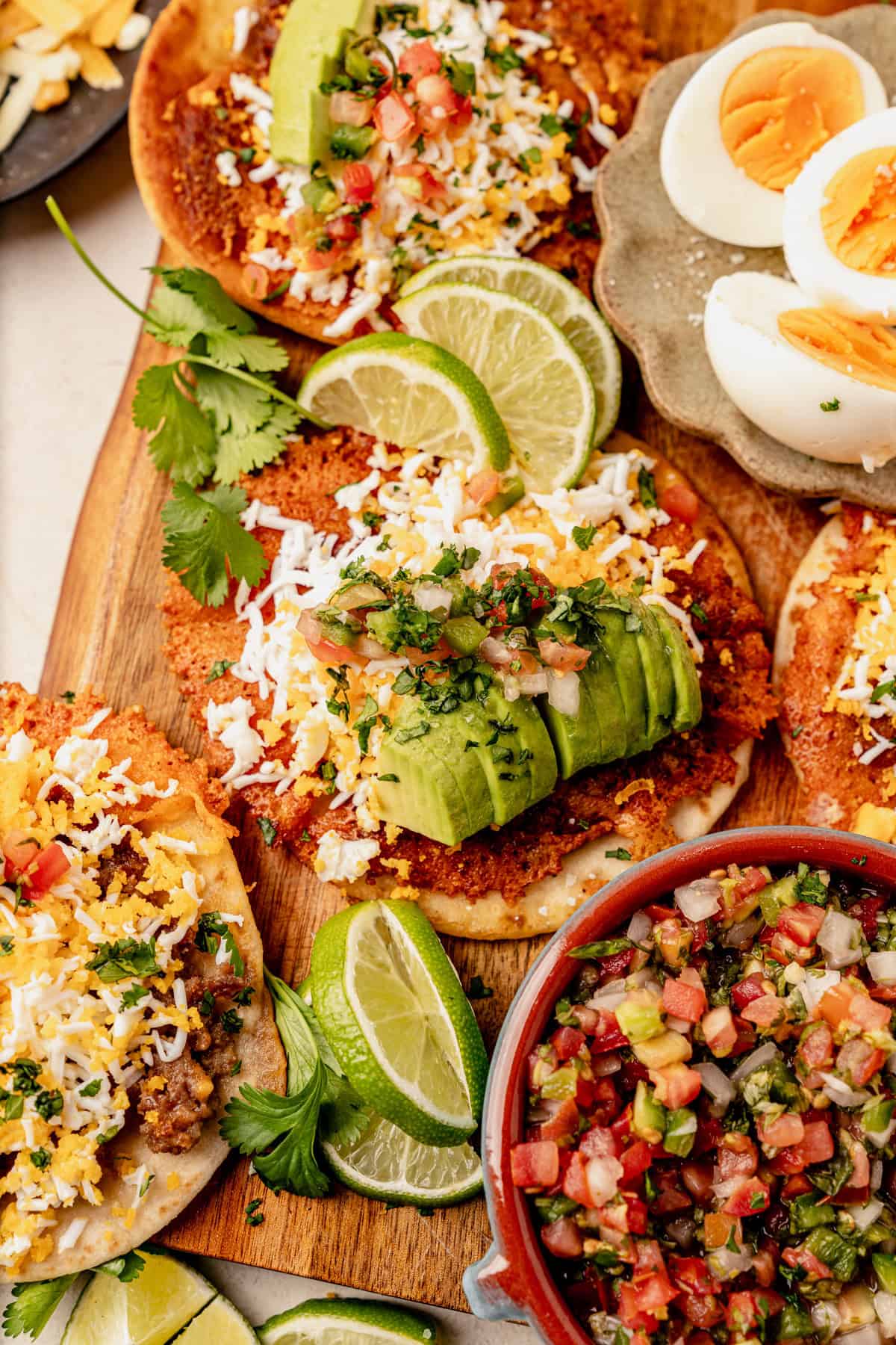 breakfast smash tacos laying flat on a cutting board with avocado and lime.