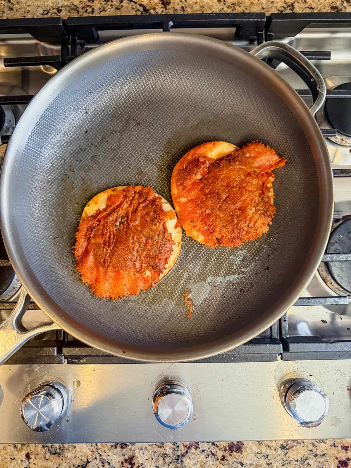 crispy cheese and breakfast sausage on a tortilla in a skillet.