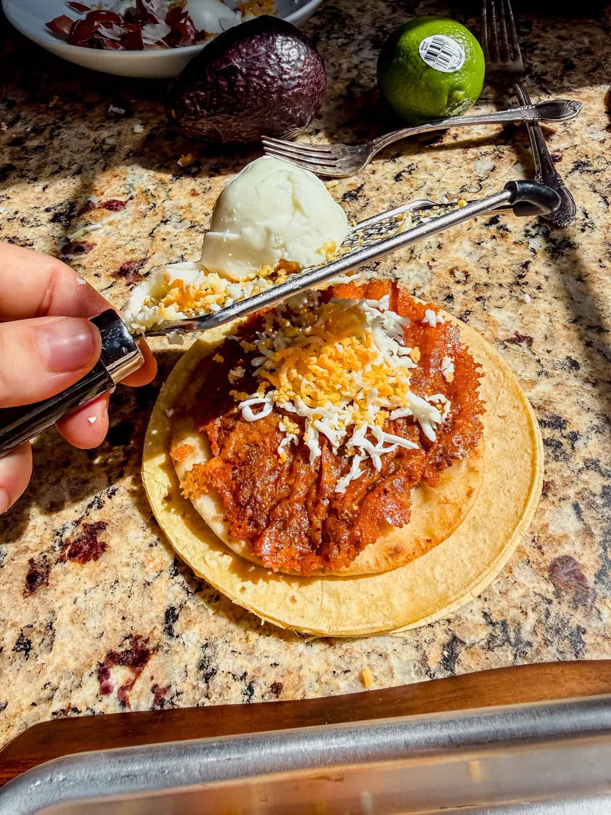 grating a hard boiled egg on top of a breakfast taco.