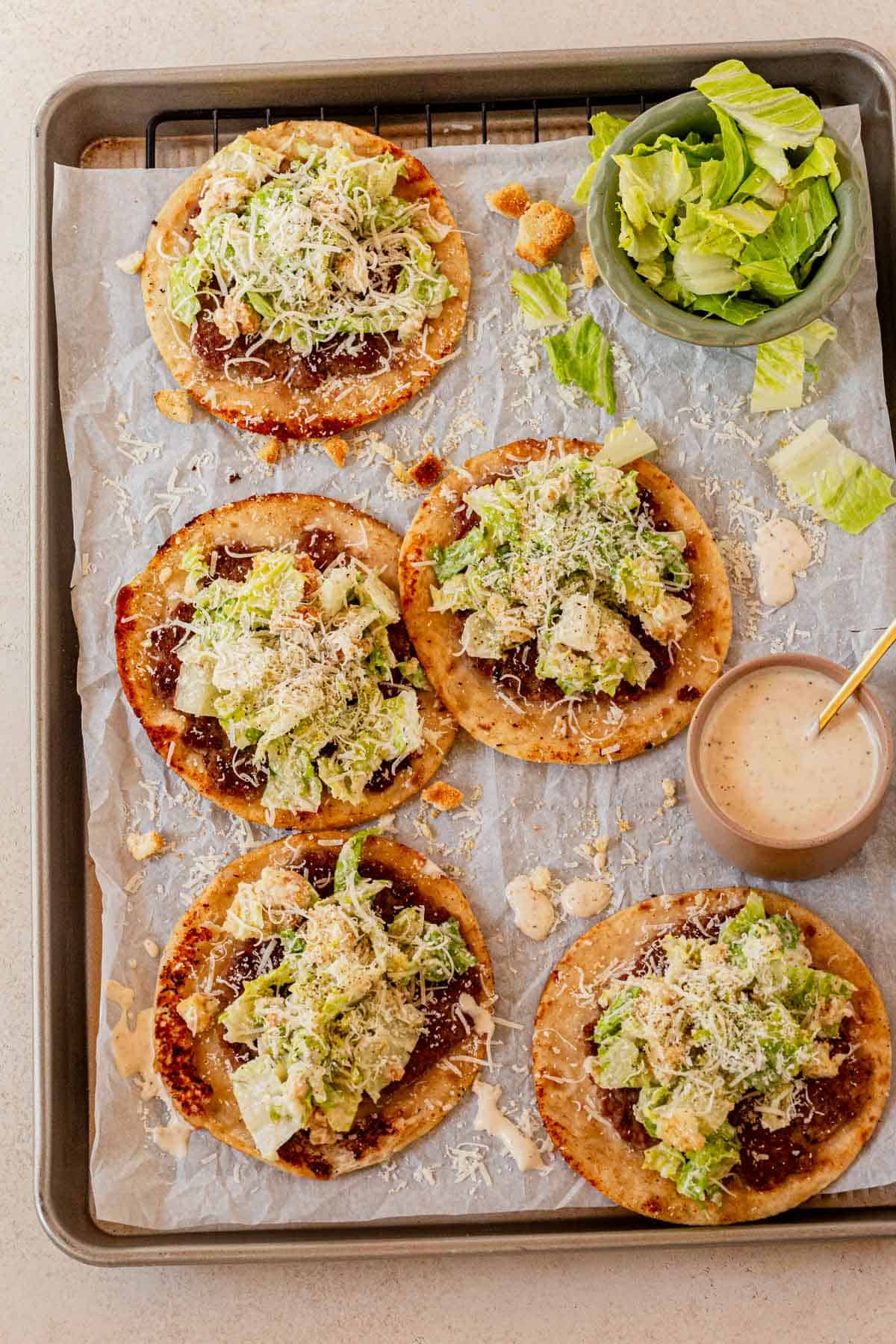 give chicken caesar smashed tacos on a serving tray with a bowl of caesar dressing.
