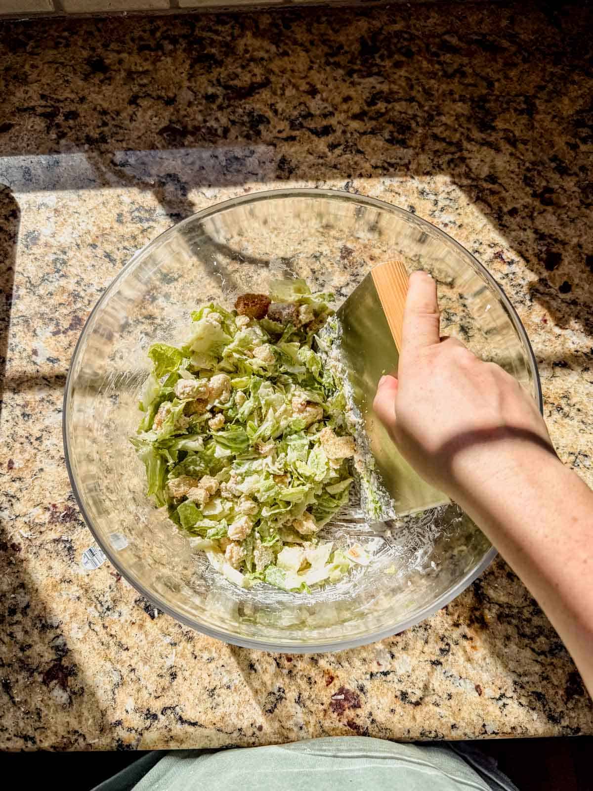 chopping caesar salad in a large bowl.