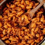 one pot creamy ground beef and shells in a skillet with a wooden spoon.