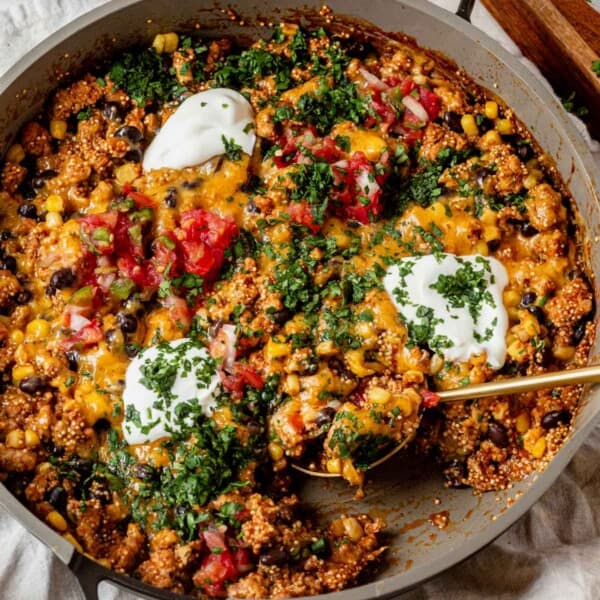 scooping a spoonful of ground turkey enchilada skillet out of the pan.