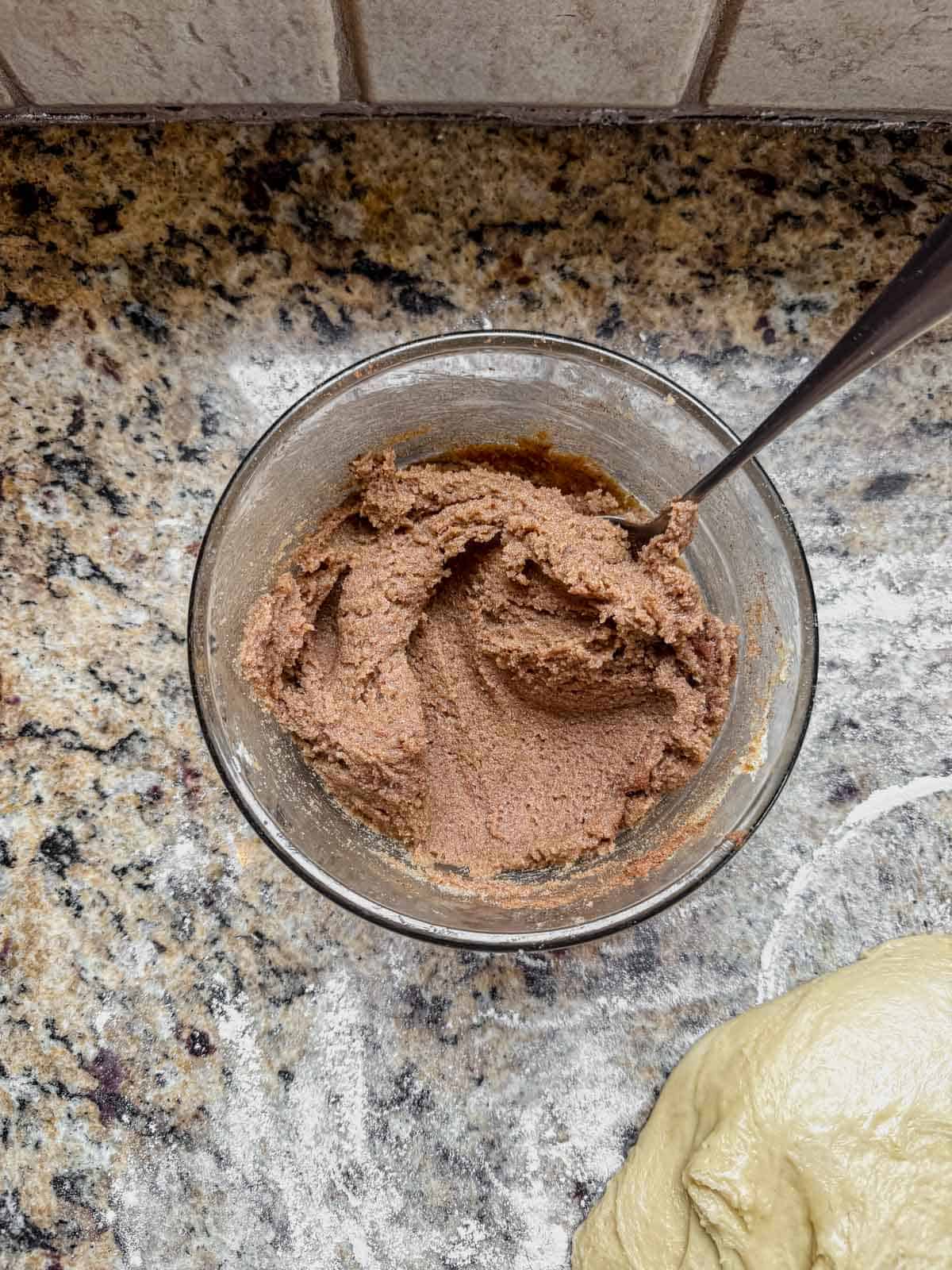 cinnamon roll filling mixed in a small bowl with a spoon.