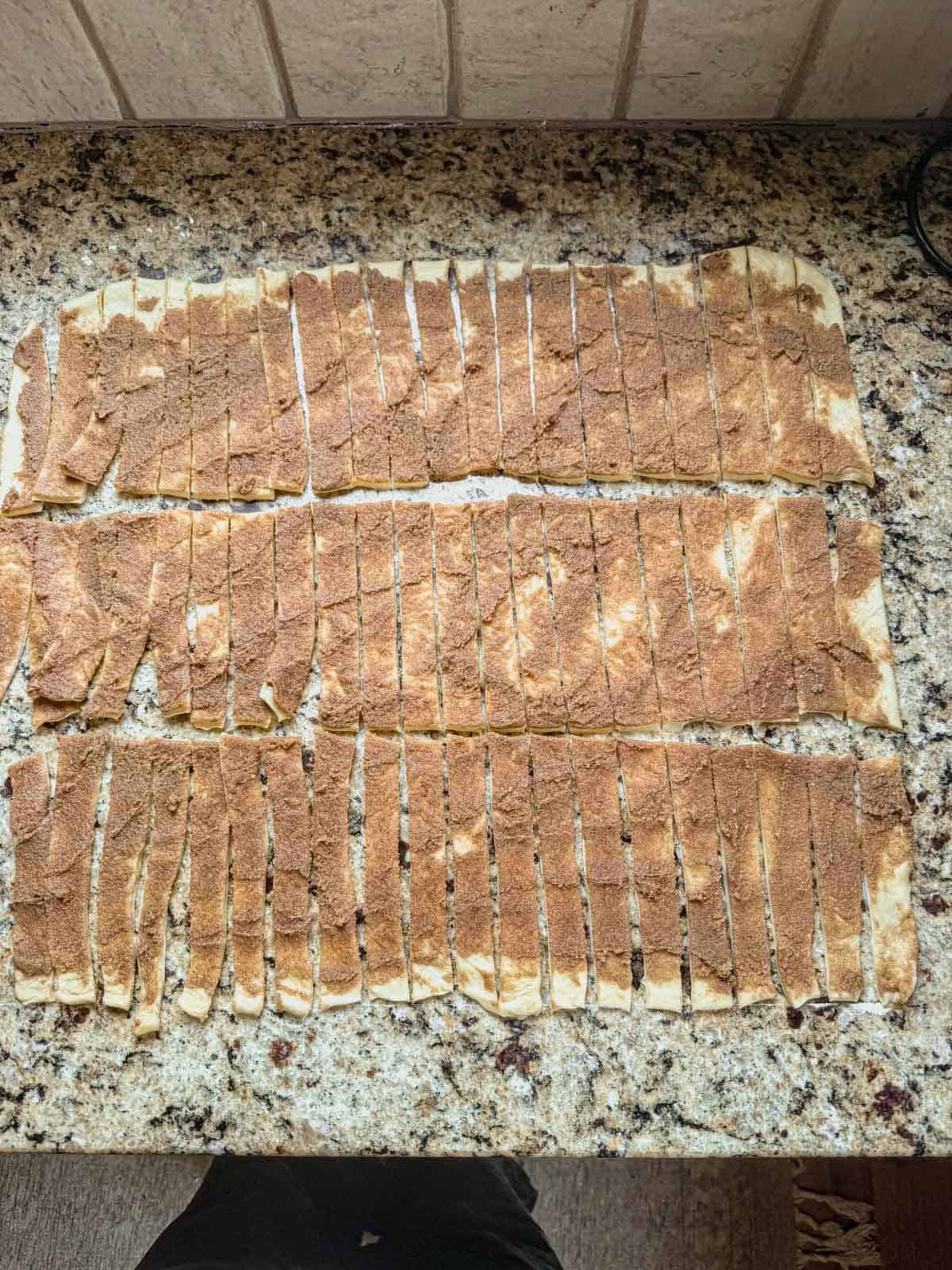 cinnamon roll dough cut into 60 small strips before rolling into mini cinnamon rolls.