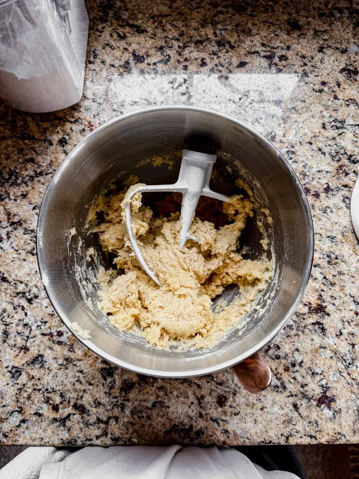 cinnamon roll dough resting in a mixing bowl.