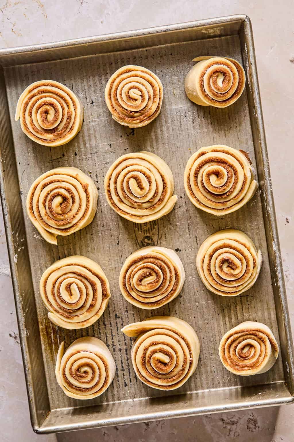 cinnamon rolls arranged in a baking pan before rising.