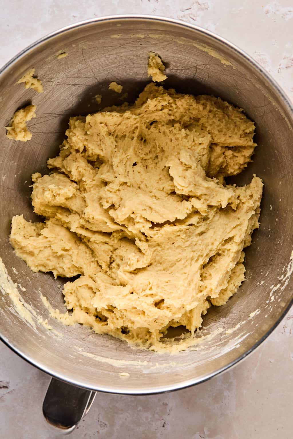 cinnamon roll dough in a stand mixer bowl after combining wet and dry ingredients.