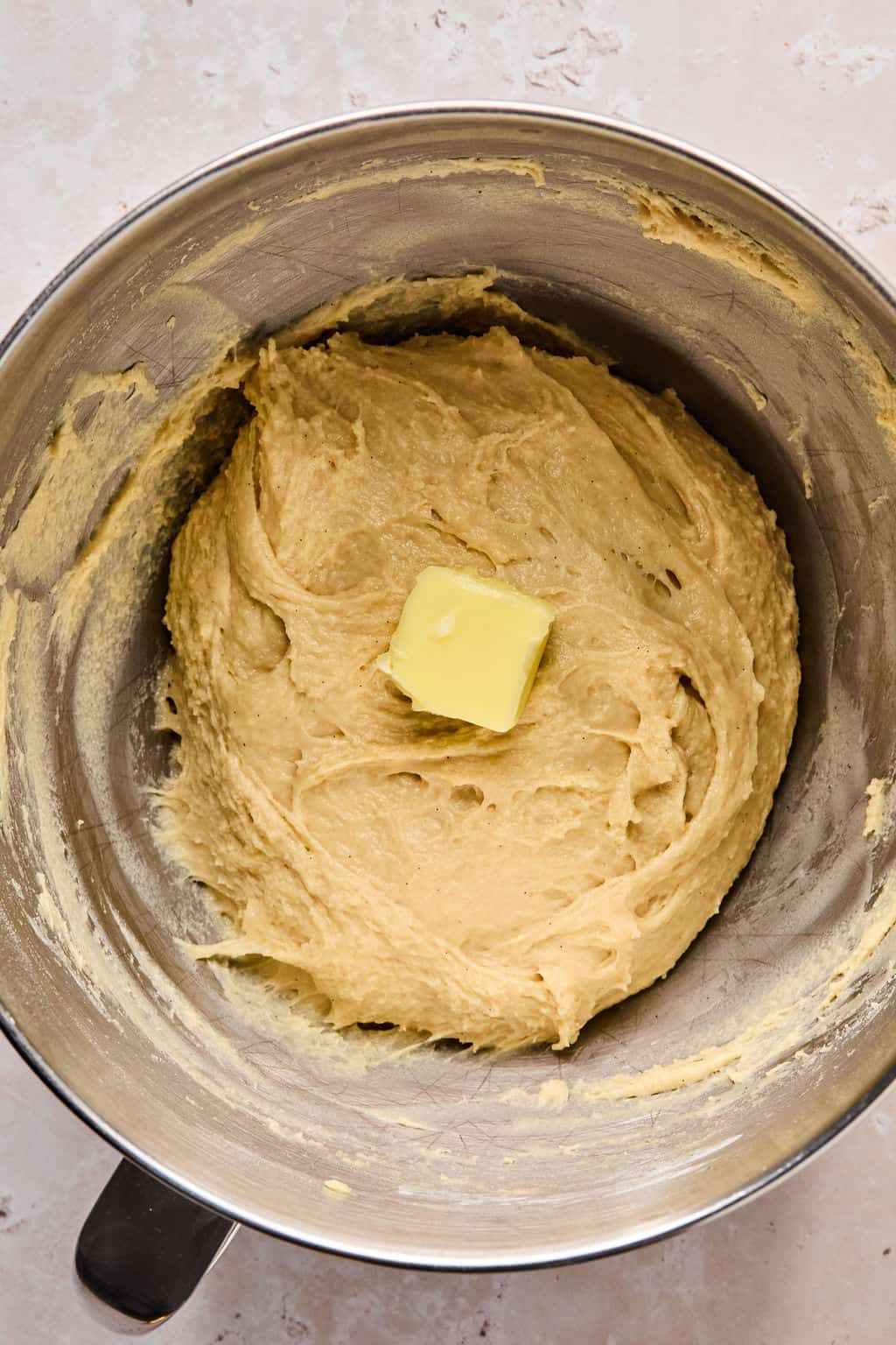 adding butter to cinnamon roll dough.