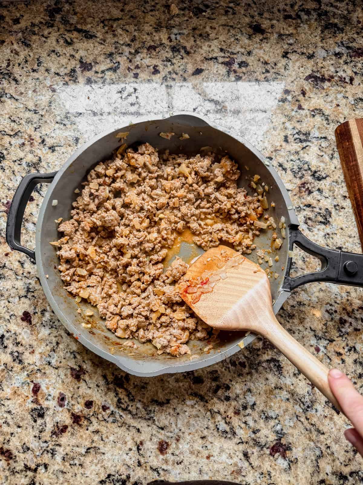 ground turkey in a skillet with bang bang sauce.
