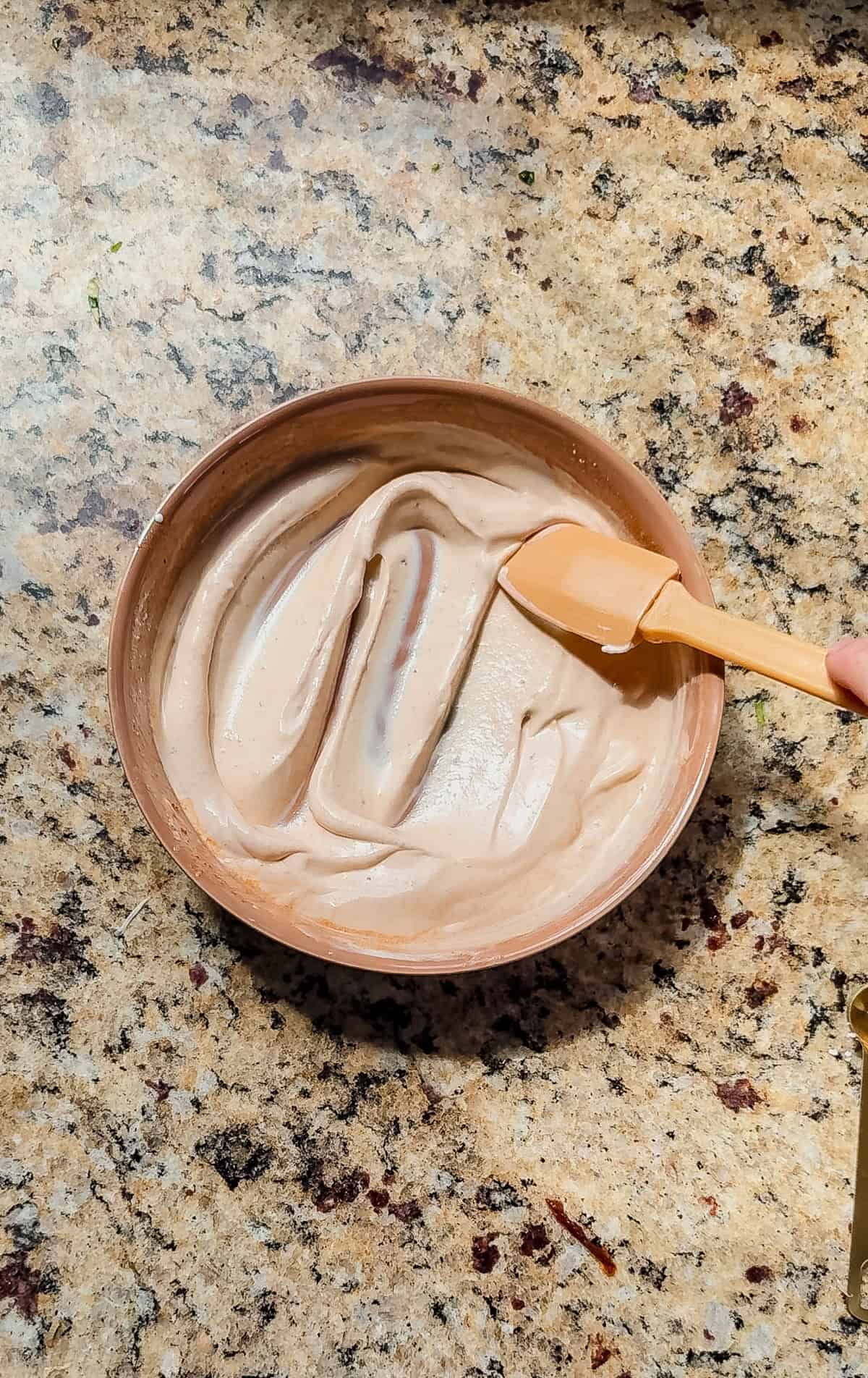 stirring chipotle crema in a small shallow dish.