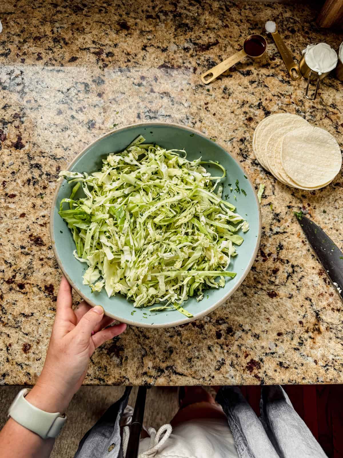 shredded cabbage slaw with cilantro in a bowl on the counter.