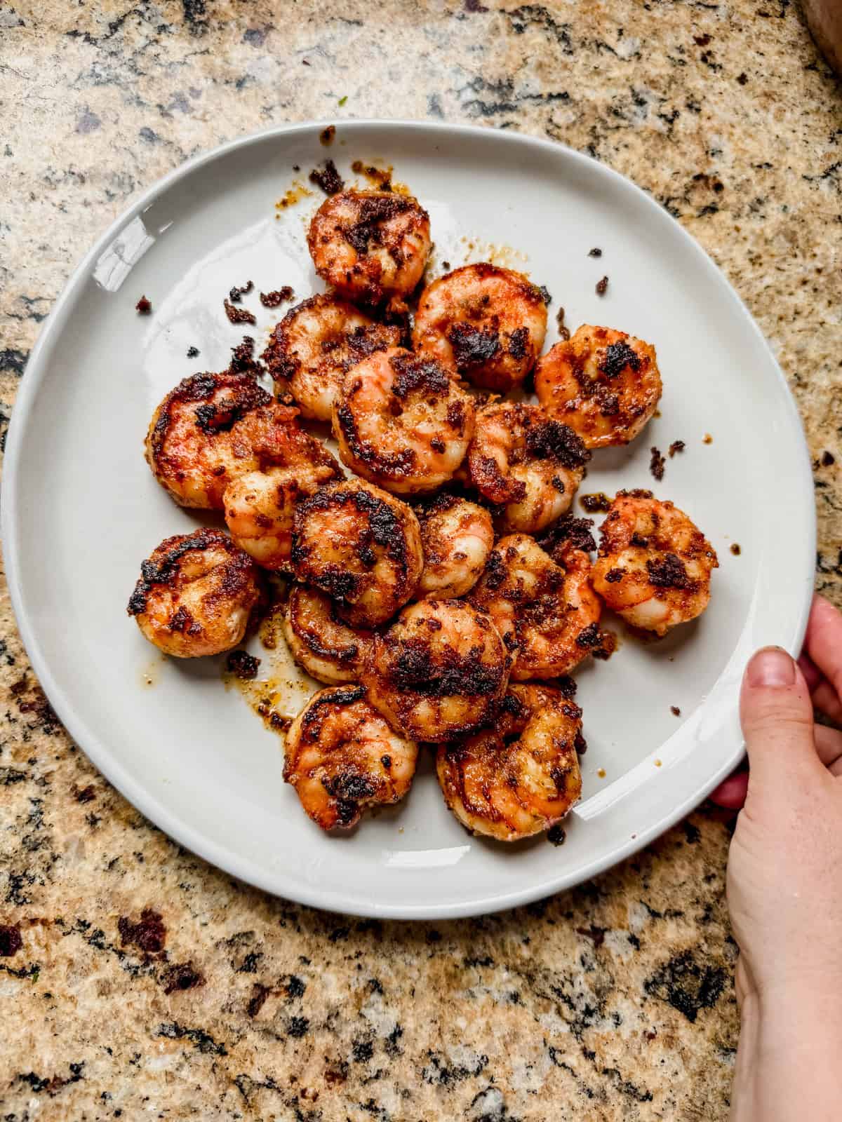 blackened shrimp on a white plate.