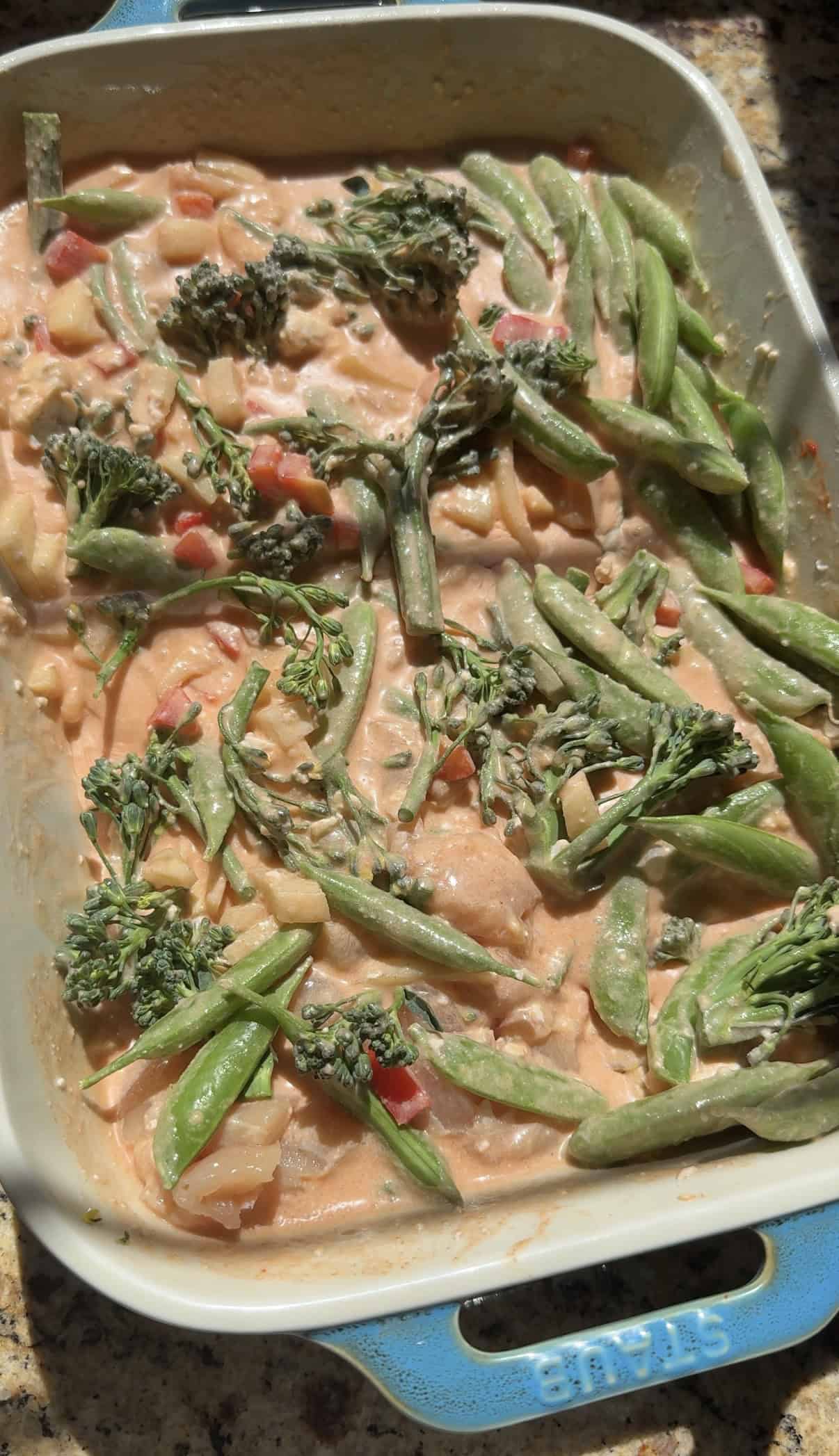 chicken curry noodles and vegetables in a baking dish before cooking.