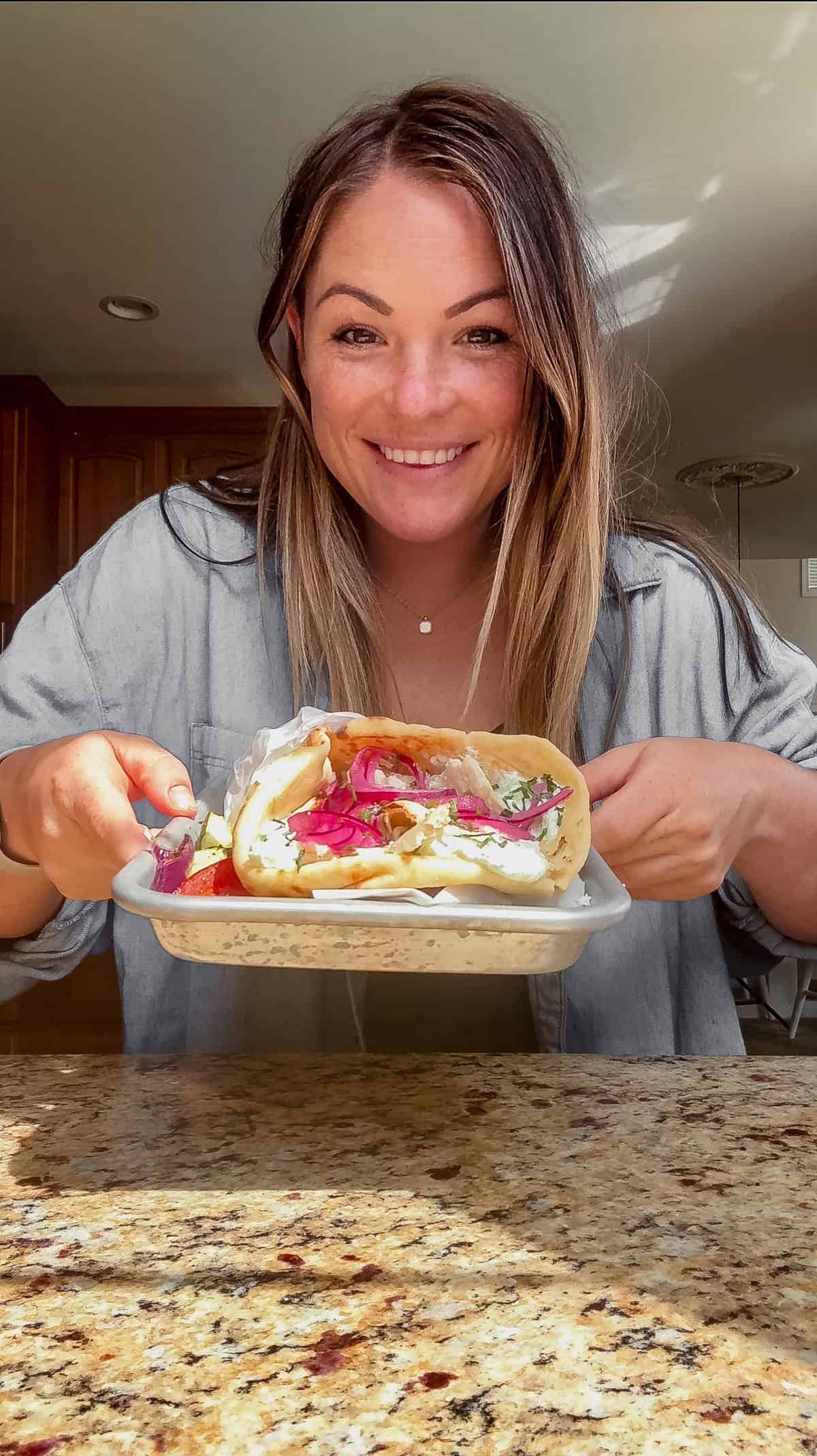molly thompson holding a chicken doner kebab wrap with roasted vegetables.