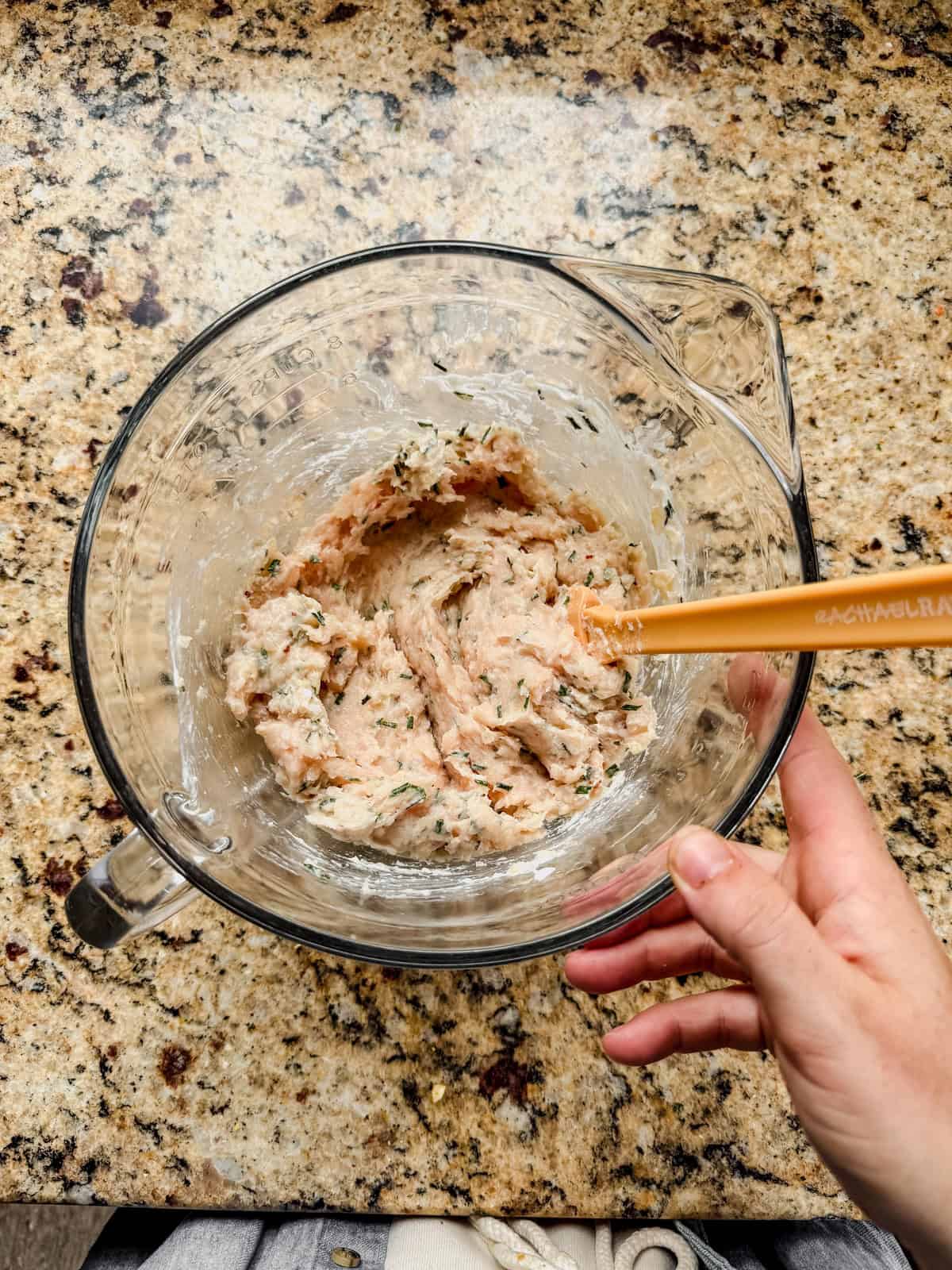 ground chicken, greek yogurt, onion, and spices mixed in a glass bowl.