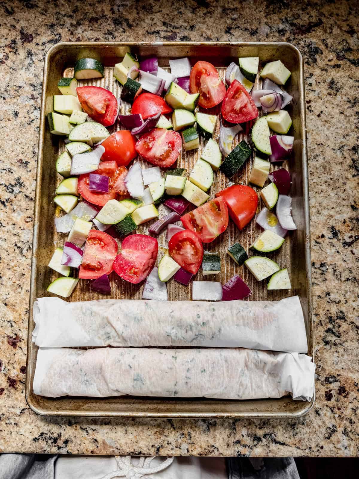 ground chicken into a log with parchment paper on a sheet pan with veggies before baking.