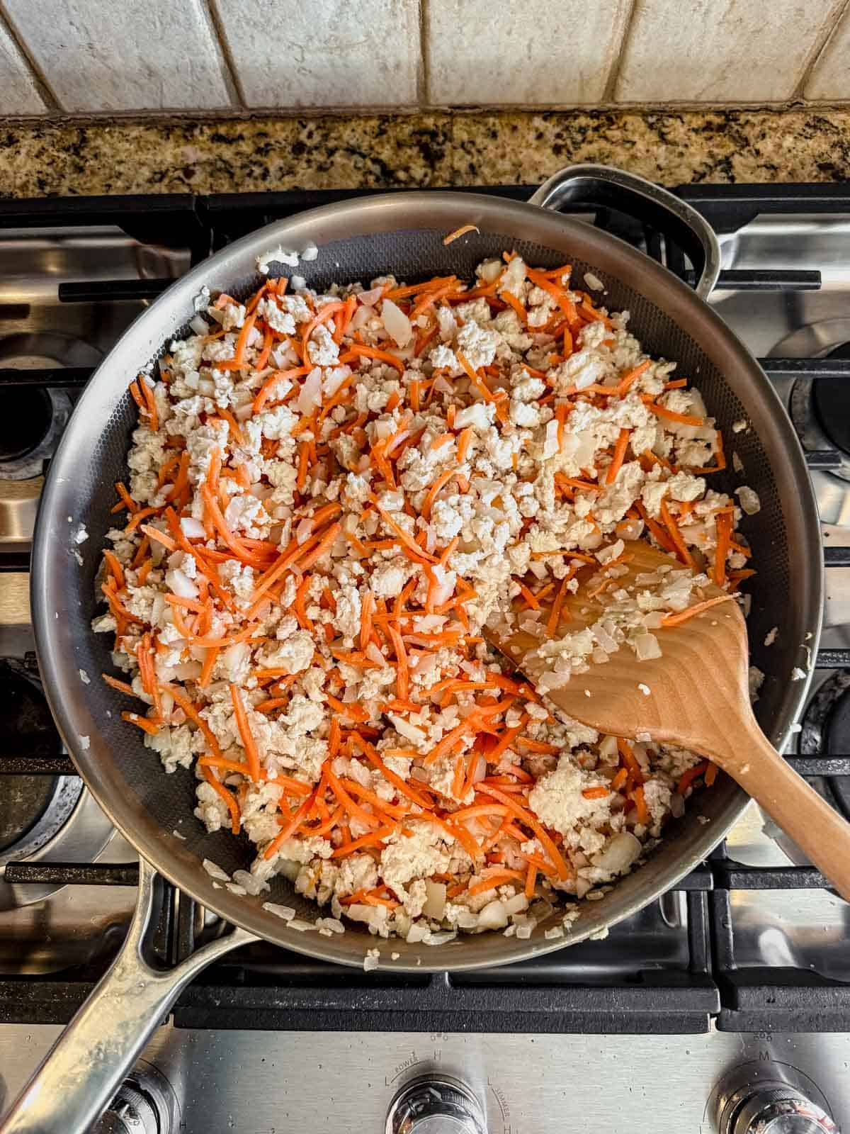 ground chicken and veggies cokked in a pan.